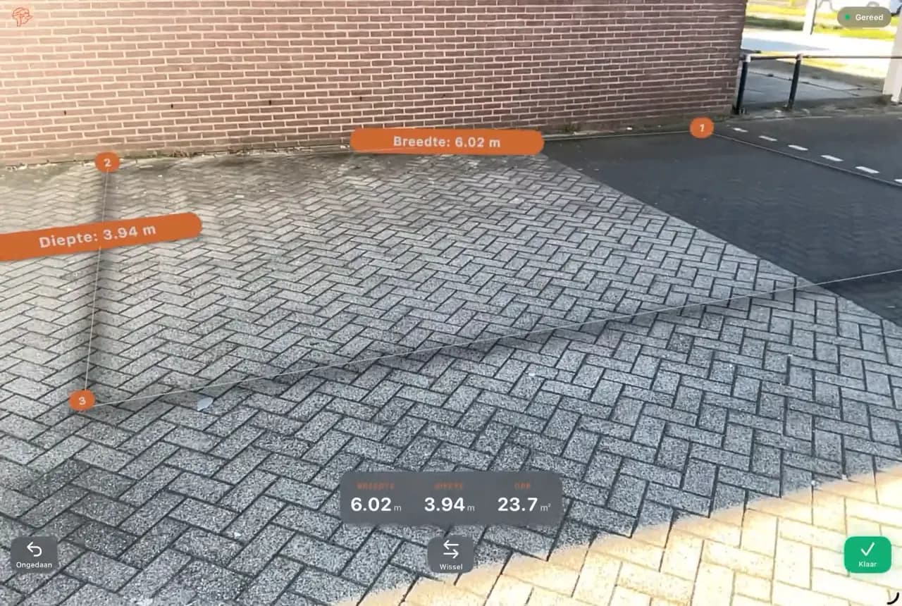 AR-Messung auf einem iPad: Breite 6,02 m und Tiefe 3,94 m auf einer Pflasterfläche an einer Mauer
